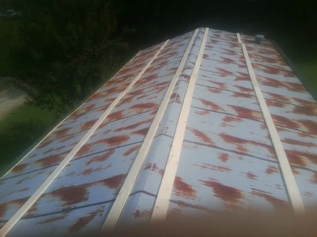 Rusted metal roof panels with new wood purlins before replacement — Storm Damage Roof Repair in Redlands by Roofing Brothers