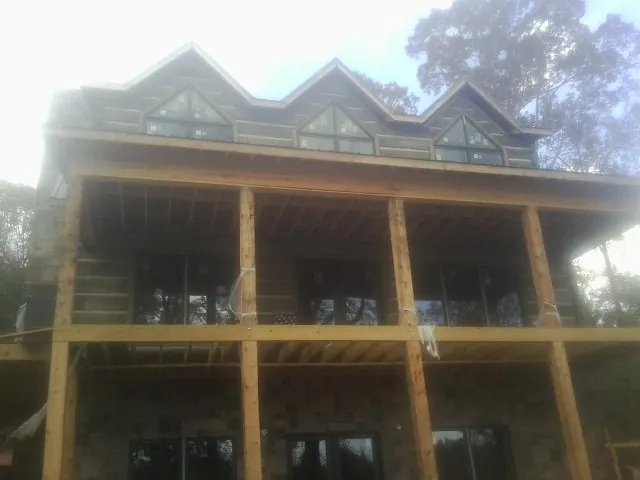 Dormers and porch framing on a large log home under construction — Roof Coating work by our crew in Redlands