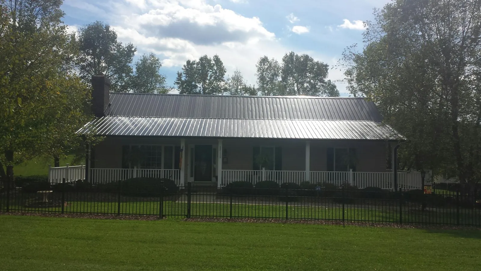 Gray metal roof on a brick ranch with a full width front porch — Gutter Guard Installation work by our crew in Redlands